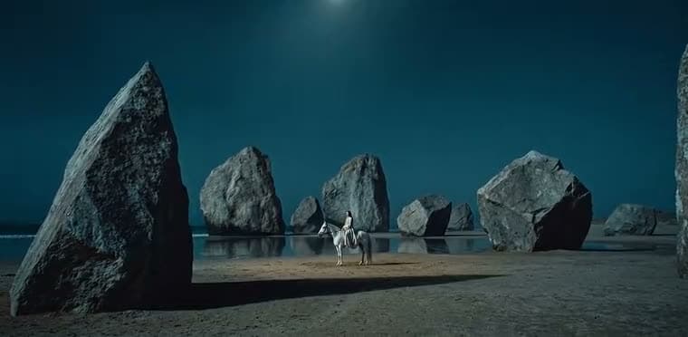 AI-generated film still — a figure on a white horse among standing stones at night